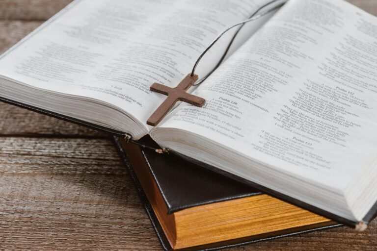 Imagen donde aparece la sagrada Biblia abierta y sobre ella un crucifijo.
