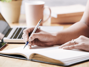  Persona escribiendo a lado del computador