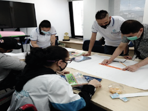 grupo de cuatro personas en preparación de cartelera para exposición