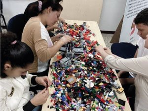 familia realizando una construcción con legos en el momento de taller