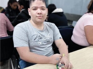 Estudiante de primaria incluyente mostrando su creación con legos.