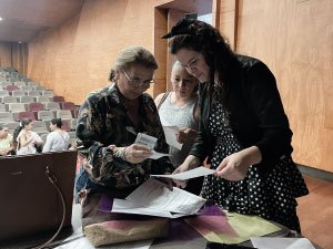 Una docente del programa de primaria incluyente, con una señora en entrega de documentos