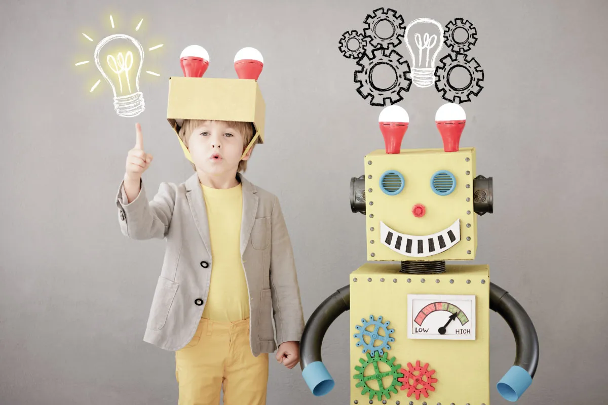 niño en proceso de innovación, con un robot a lado