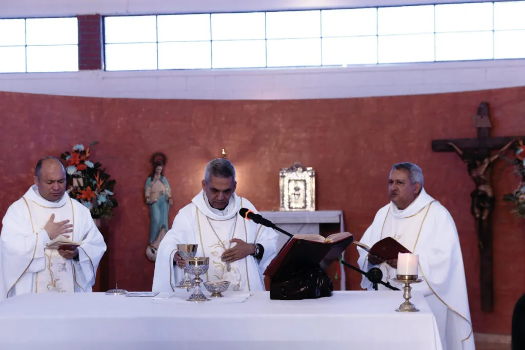 Tres sacerdotes oficiando una eucaristía.
