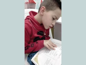 Niño estudiante del Cibercolegio leyendo.
