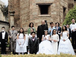 Fotografía de primeras comuniones de alumnos del Cibercolegio con el rector del Cibercolegio Pbro. Eduin Salazar en periodo 2021