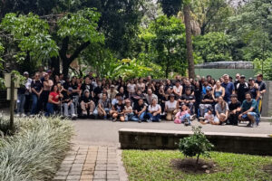 Estudiantes, acompañantes y representantes del programa Resilientes del Cibercolegio UCN durante una salida pedagógica al Parque de la Conservación de Medellín, reunidos en una fotografía grupal en un entorno rodeado de vegetación.